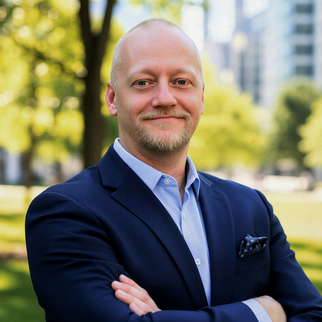 picture of Chad Nedland standing with arms crossed in front of himself with a smile on his face.